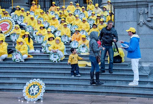 '图11:温哥华市民Arman先生带着太太Maria女士和儿子一起主动加入温哥华法轮功学员烛光守夜活动。'