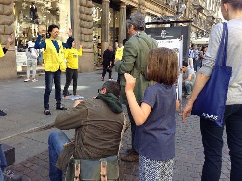 '图2:法轮功学员炼功吸引人们观看,图为跟着学功的小女孩'