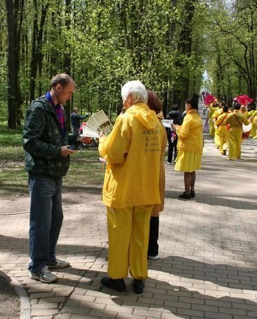 '图12~13:在公园游行中向旁边的民众发真相资料'