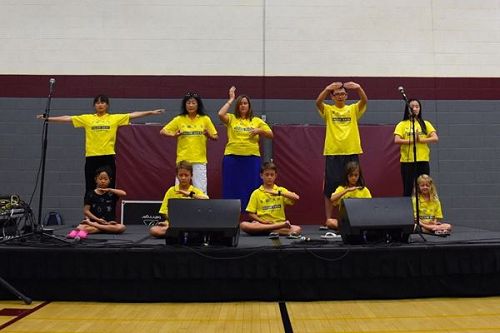 '图5~7:中西方法轮功学员们在舞台上展示五套优美祥和的功法'