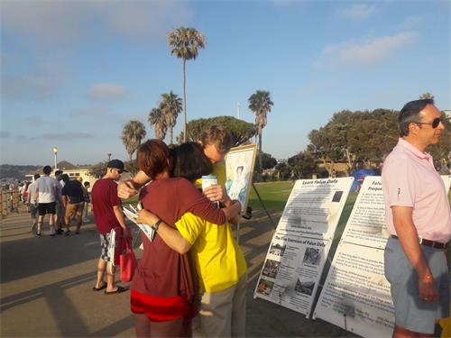 &#039图7：深受感动的瑞恩（Ryan）和米娅（Mia）拥抱了和他们交谈的法轮功学员&#039