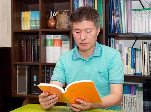 '图1：李惇荣律师在读法轮大法书籍。'