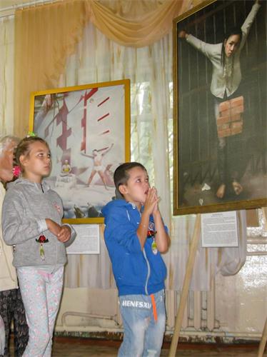 &#039图5：看到画中的女法轮功学员被酷刑折磨，小男孩感到震惊。&#039