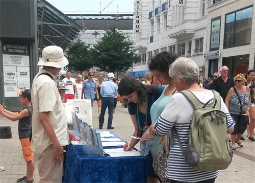 '图8:了解真相的人们,签名支持法轮功学员制止迫害。'