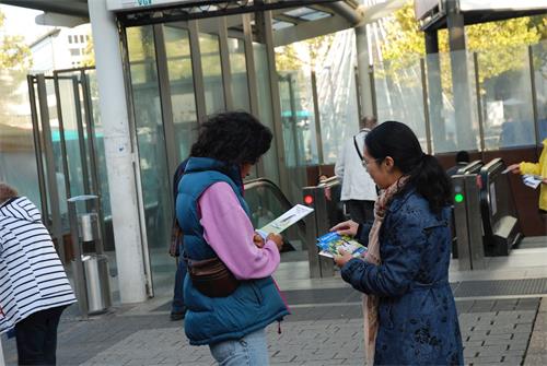 '图7~9:法轮功学员在图书展外箱民众发放真相传单'