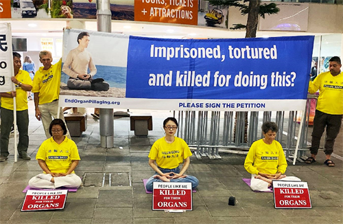 &#039图1：步行街上，法轮功学员祥和的打坐场景，向路人展示法轮大法的美好&#039