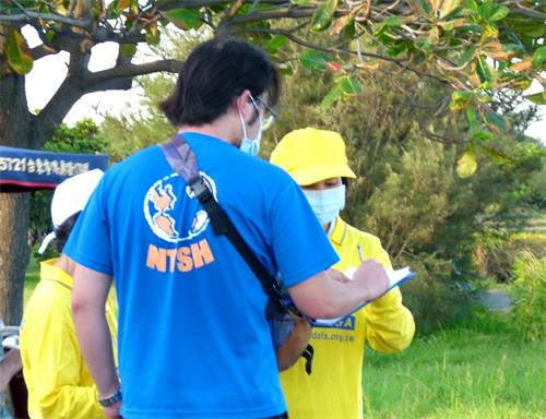 '图5：法轮功学员向民众传递真相，人们签名声援法轮功反迫害。'