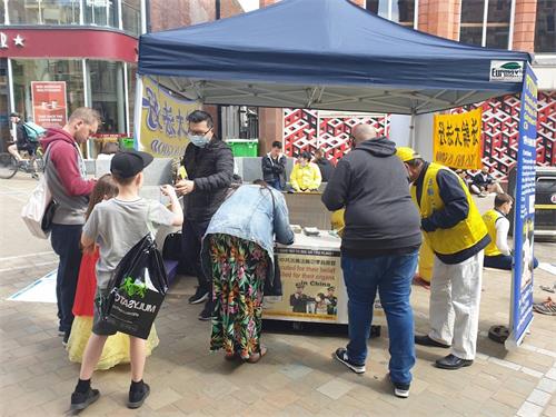 '图4~7:很多民众驻足了解真相并签名支持法轮功反迫害'