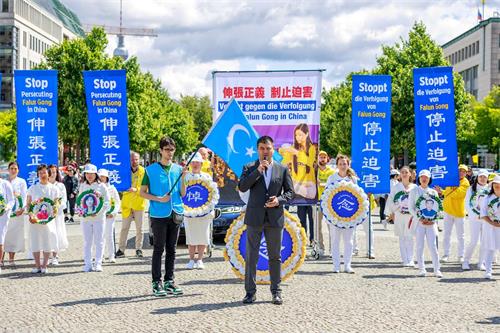 &#039图11：世维大会主席多里坤·艾沙（Dolkun Isa）委派柏林办公室主任海玉儿·库尔班（Haiyuer Kuerban）参加了法轮功学员在勃兰登堡门的集会。&#039