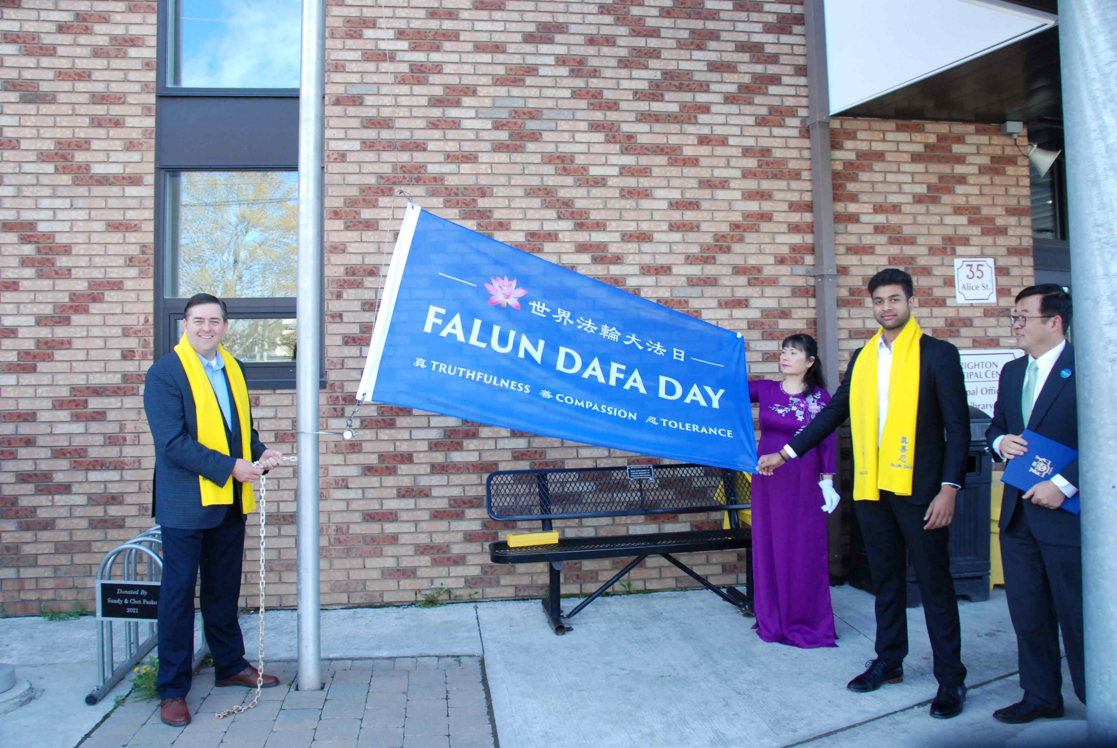 图11:二零二四年五月三日,加拿大布莱顿市市长布赖恩·奥斯特兰德(左一)亲自升起“世界法轮大法日”的旗帜。