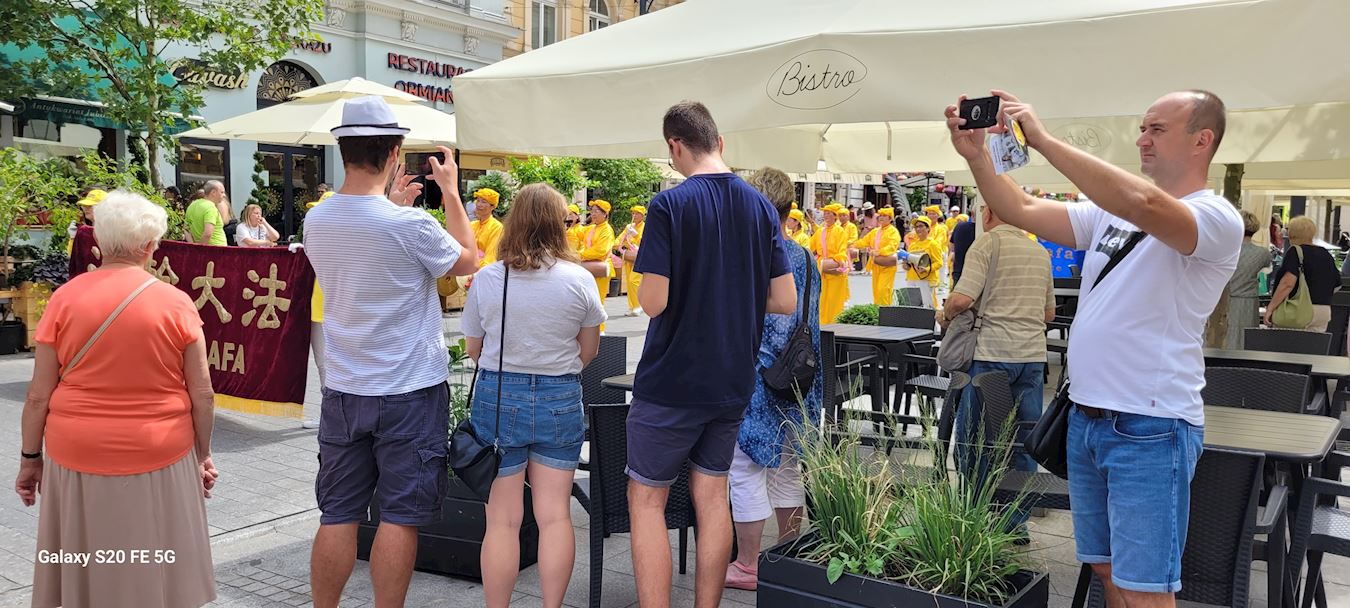 '图16~17:游行队伍所经之处挤满了观看的人群,众人纷纷拿出手机相机录像机拍照'