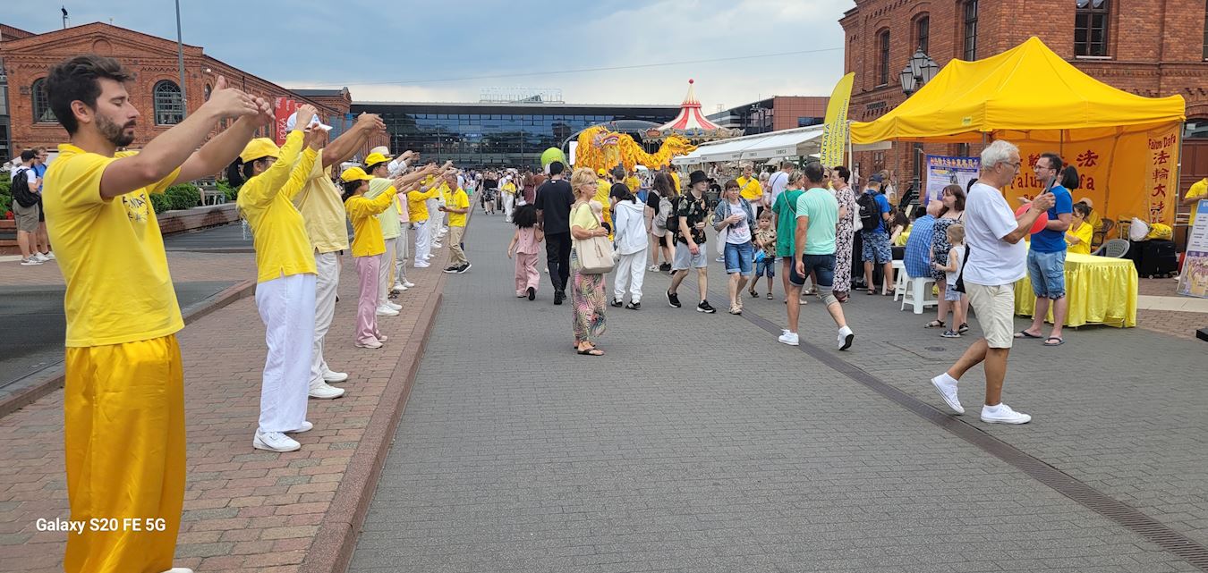 '图20~21:在游行终点站,法轮功学员在现场弘法并展示法轮功功法'