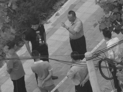 '二零一五年八月七日，三河市法院对法轮功学员王占青等四人第三次非法非法开庭。一大早，国保大队长石连东（中）布置任务，穿绿上衣者是李伟。'